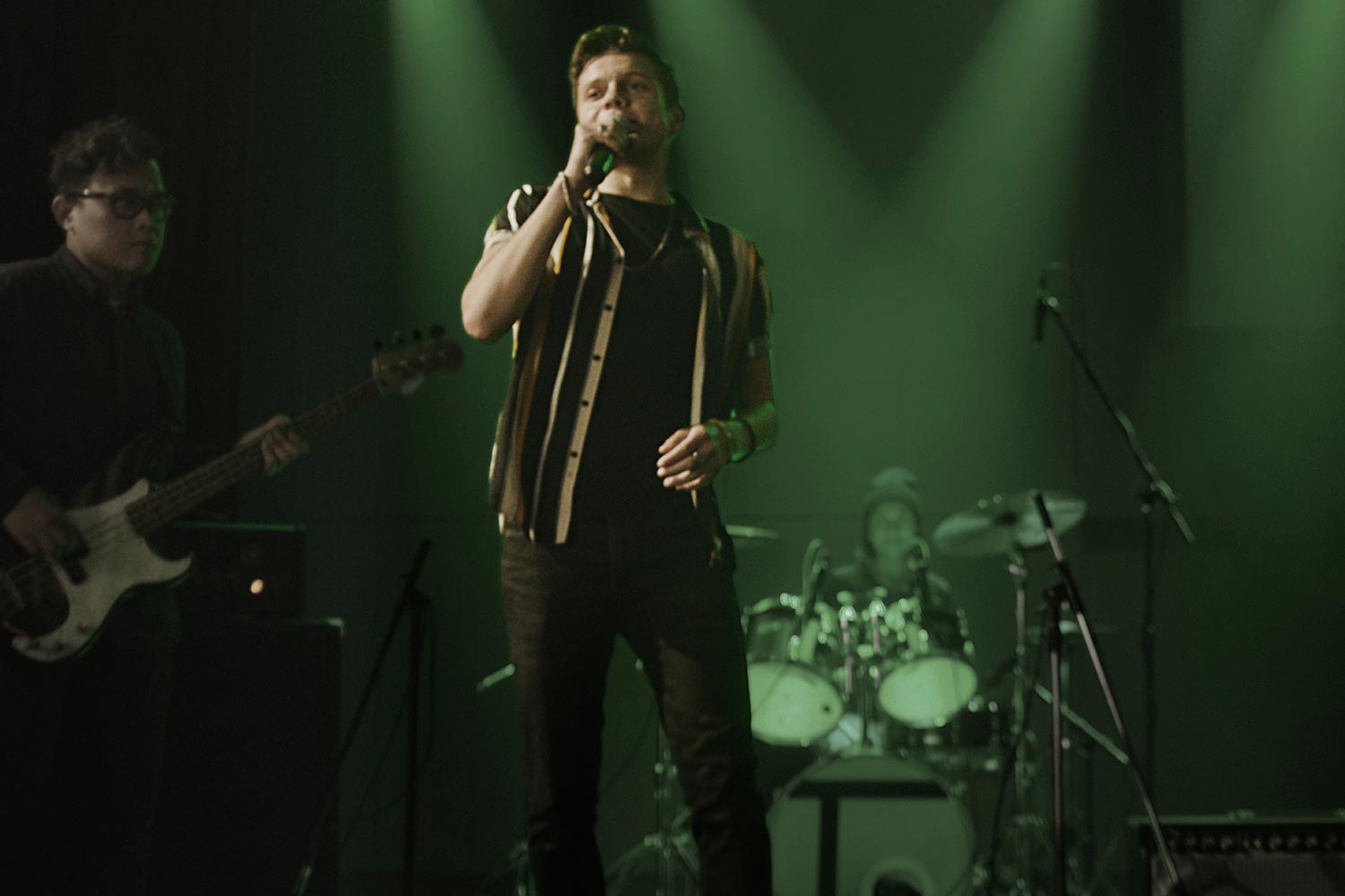 Man singing on a stage with green lights